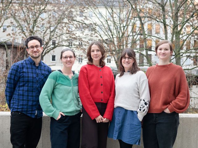 Vier Frauen und ein Mann lächeln in die Kamera