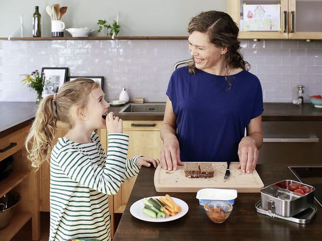 Mutter und Tochter bereiten ein Pausenbrot zu.