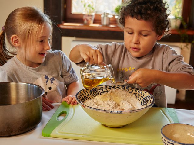 Zwei Kinder bim Zubereiten eines Teigs