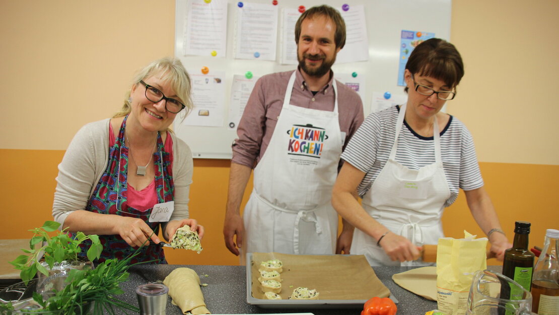 Zwei Pädagog:innen kochen gemeinsam mit einem Trainer der Sarah Wiener Stiftung im Rahmen einer Ich kann kochen! Fortbildung.    