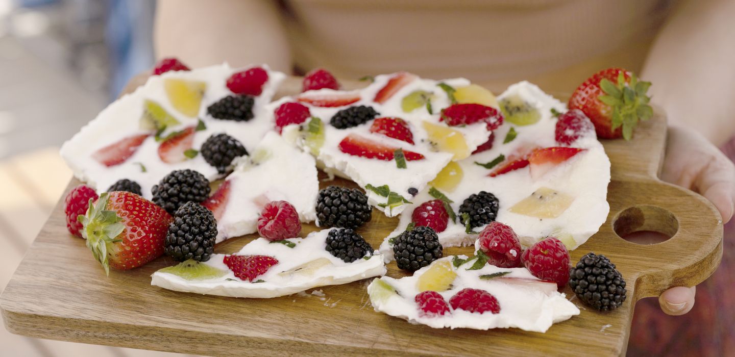 In Stücke gebrochener Eis-Joghurt mit Obst und Beeren
