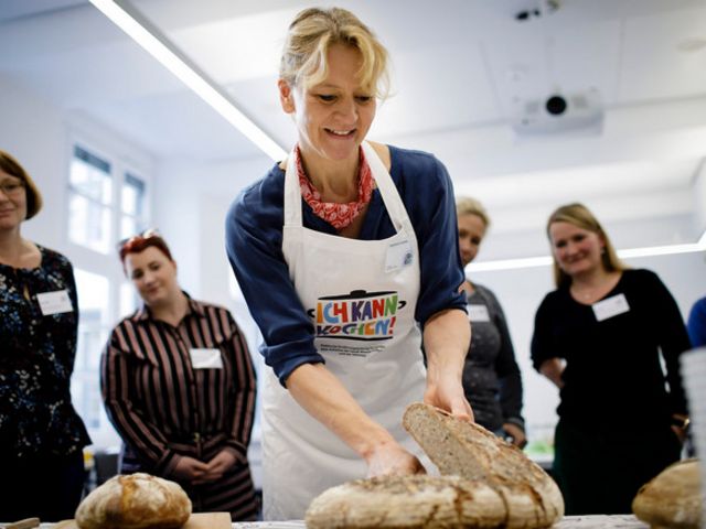 Fortbildungsteilnehmerin schneidet einen Laib Brot