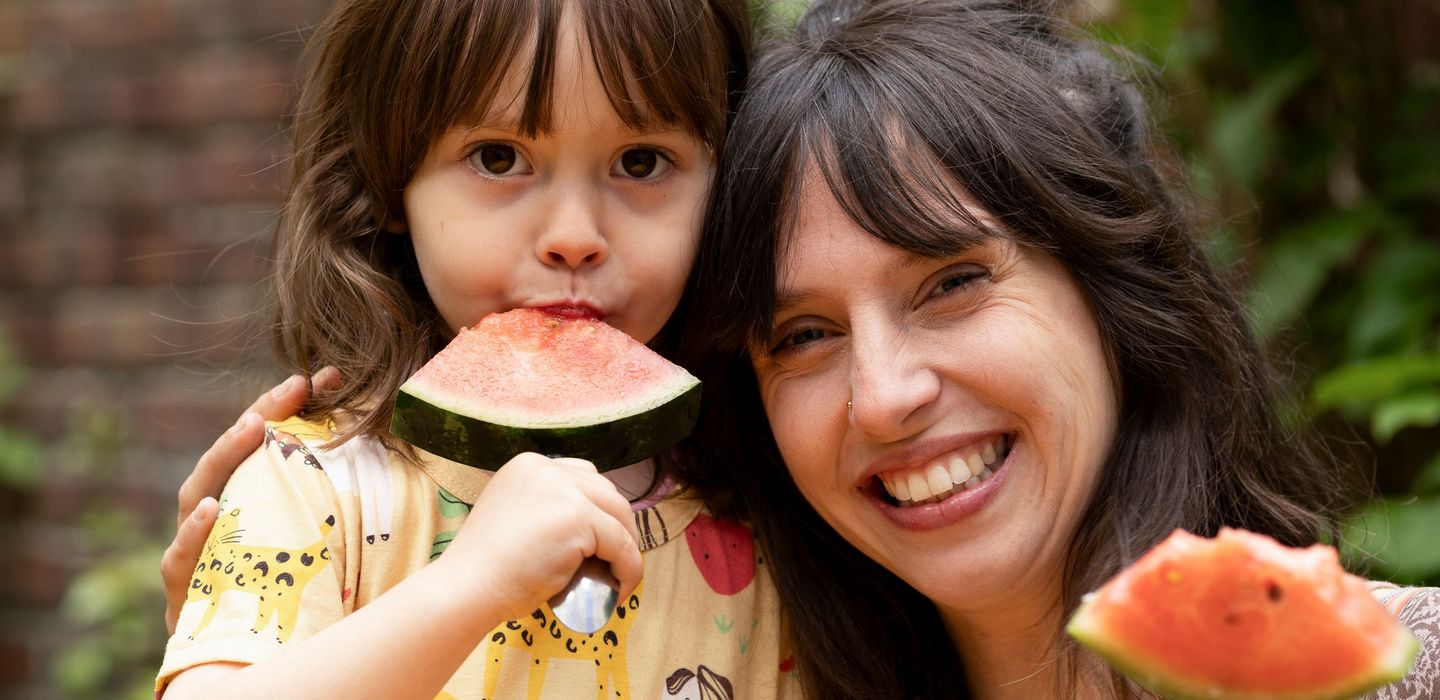 Mutter und Kind genießen ein Meloneneis am Stiel