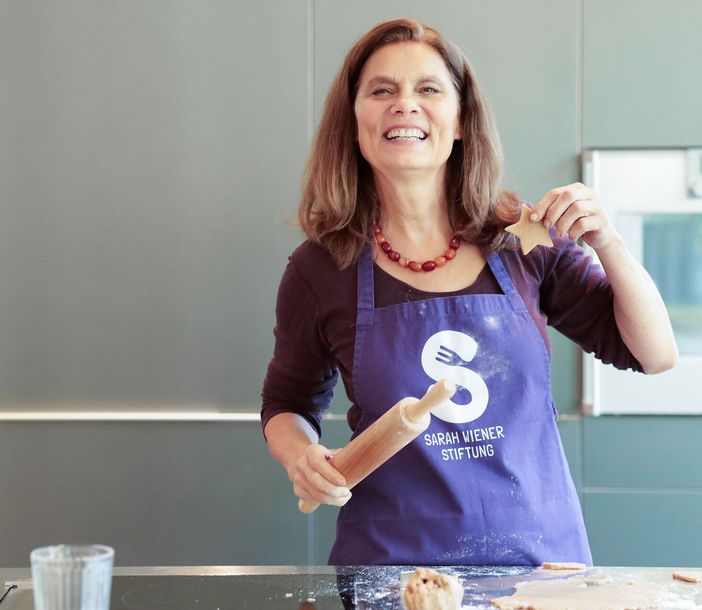 Sarah Wiener mit Nudelholz und Plätzchen in der Hand