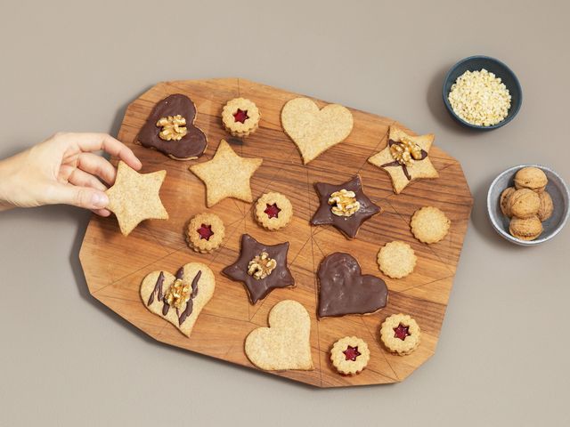 Butterplätzchen mit verschiedenen Verzierungen auf einem Holzbrett