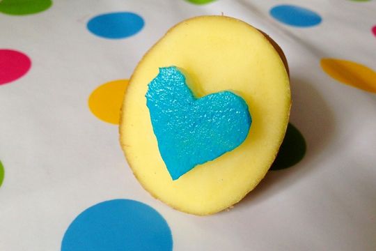 Ein Kartoffelstempel in Herzform mit blauer Farbe