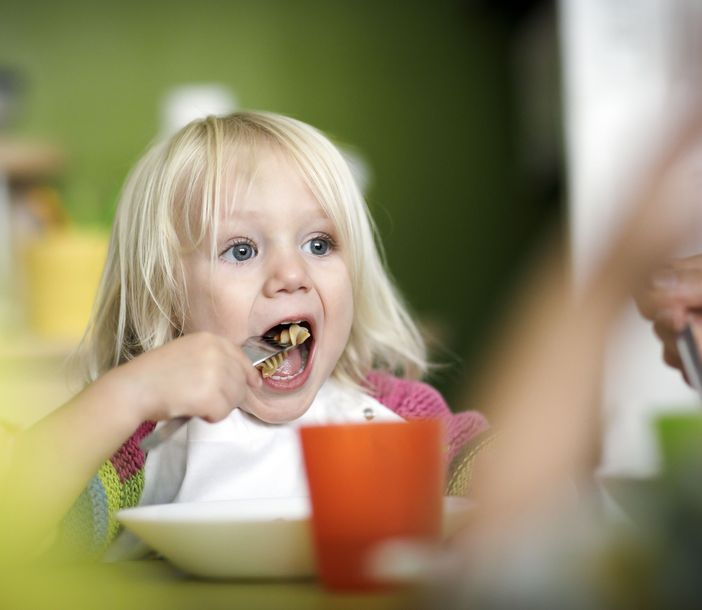 Ein Kind isst Nudeln