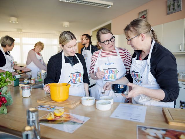 Fortbildungsteilnehmende probieren mit Trainerin Rezepte in der Küche aus