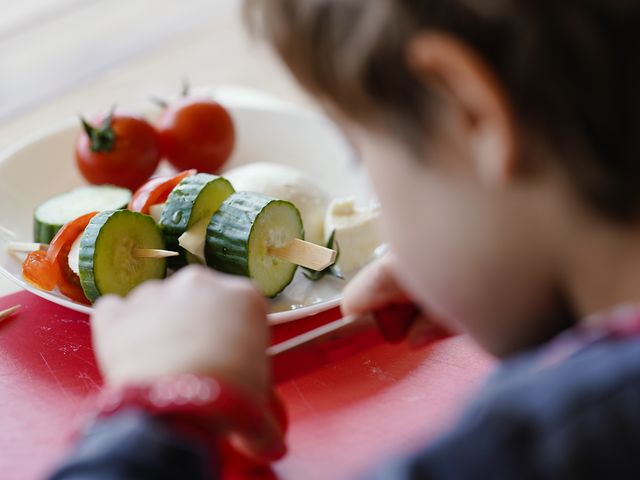 Junge bereitet Gemüsespieße zu