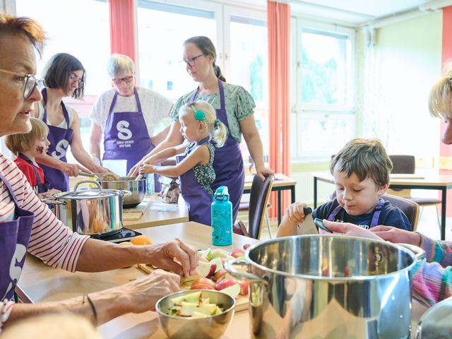 Kinder und Erwachsene kochen zusammen