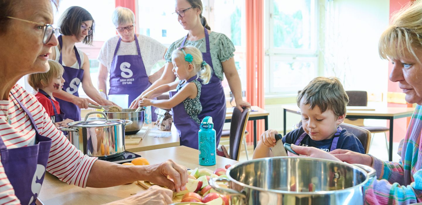 Kinder und Erwachsene kochen zusammen