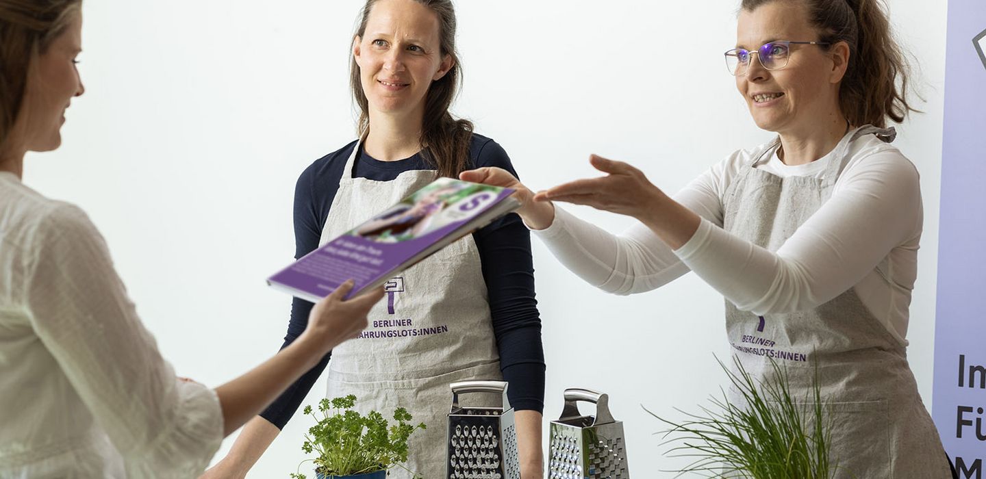 Eine Frau reicht zwei Frauen ein Magazin