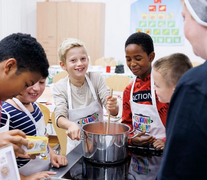 Jungen bereiten eine Suppe gemeinsam zu