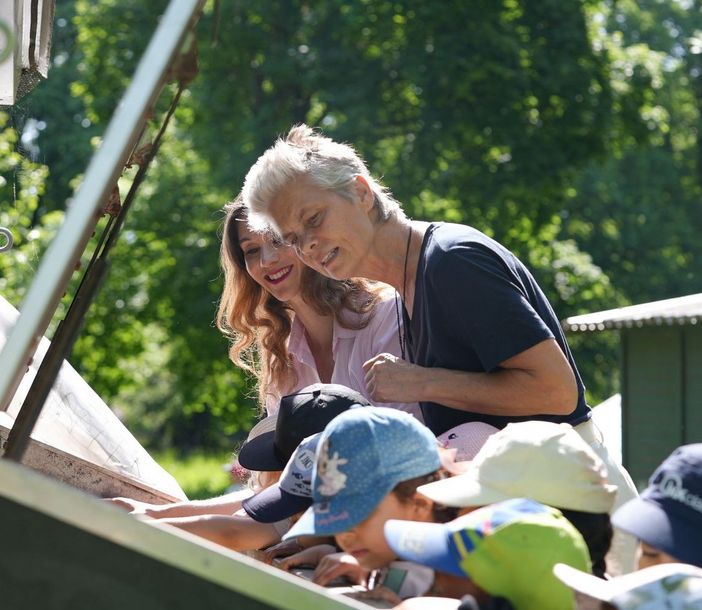 Janina Lin Otto, Sarah Wiener und Kinder gucken in eine Luke