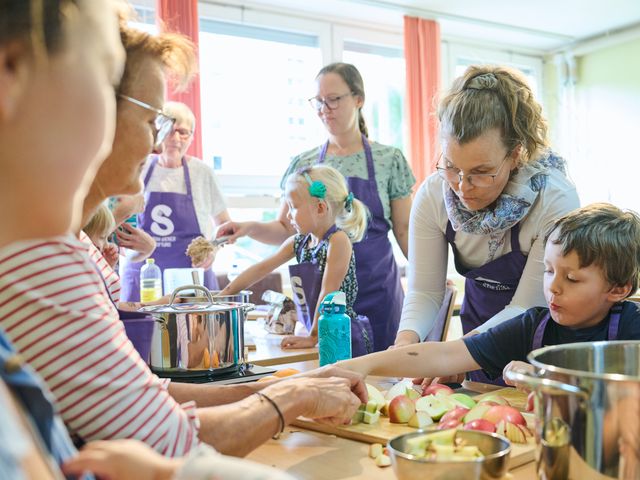 Kinder und Erwachsene kochen zusammen