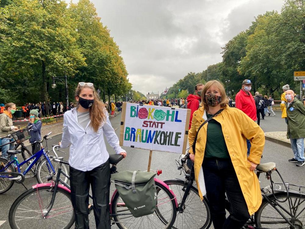 Mitarbeiter:innen der Sarah Wiener Stiftung auf dem Klimastreik in Berlin mit einem Schild auf dem "Biokohl statt Braunkohle" geschrieben steht.  